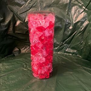 Red and Pink Plastic Rocks in clear plastic cylinder.